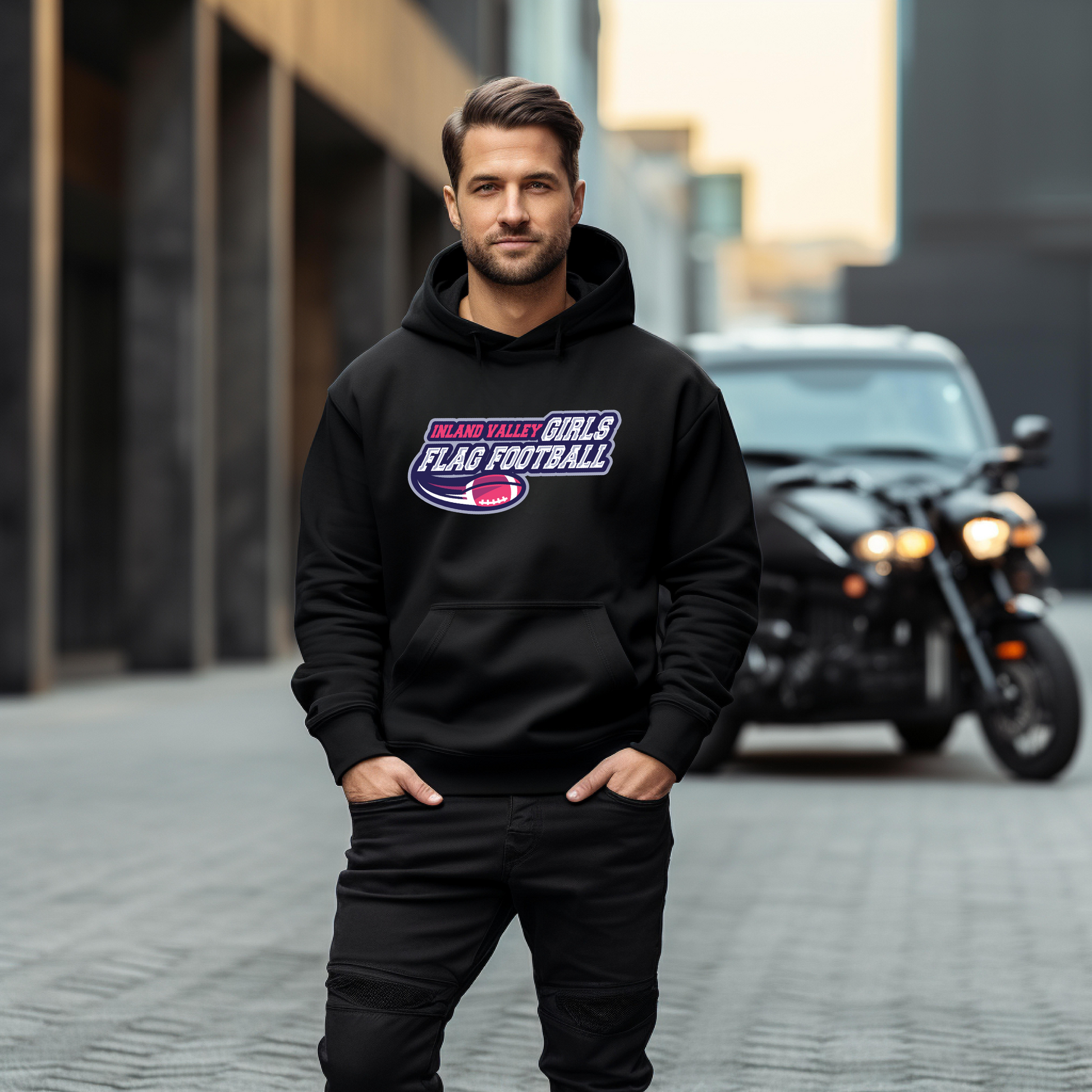 Man wearing a black hoodie with 'Flag Football' text, standing in front of a motorcycle.